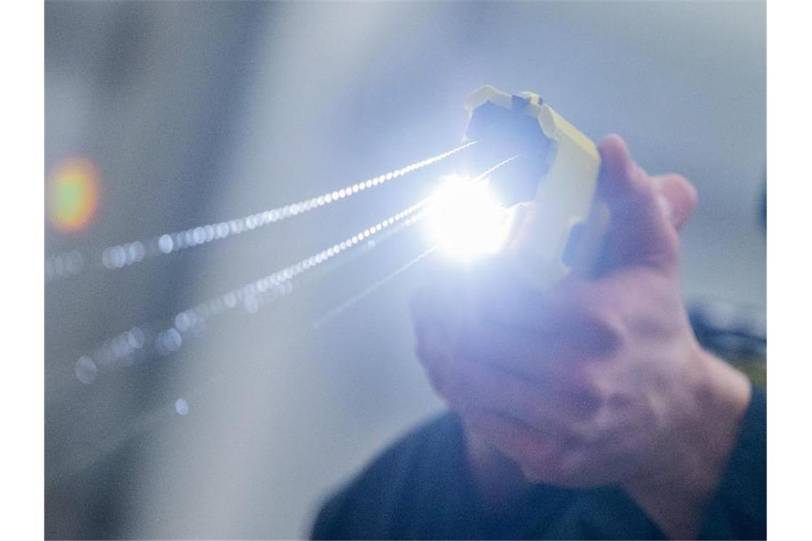 Taser-Bilanz fällt in Ländern unterschiedlich aus Ein Polizeibeamter demonstriert einen Schuss mit einem Taser. Foto: Rolf Vennenbernd/dpa