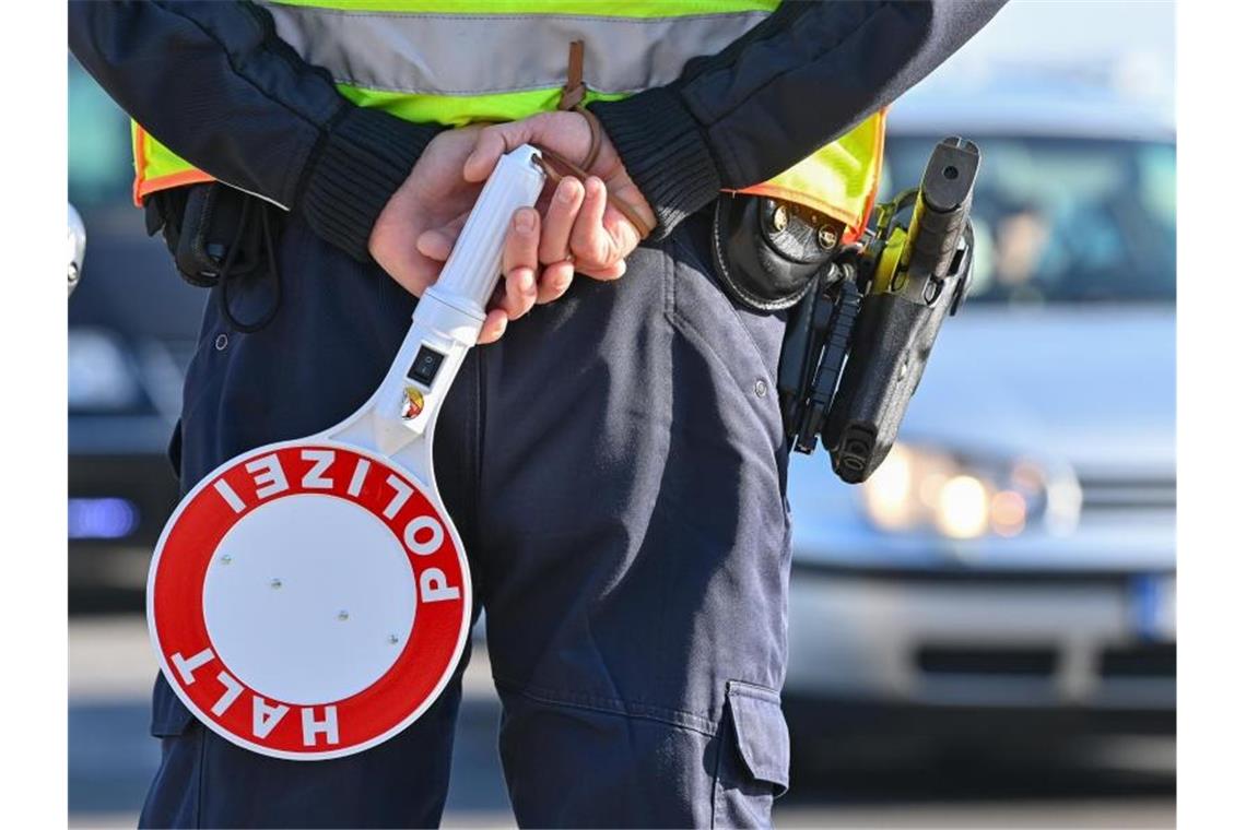 Ein Polizeibeamter hält eine Winkerkelle in den Händen. Foto: Patrick Pleul/dpa-Zentralbild/ZB/Symbolbild