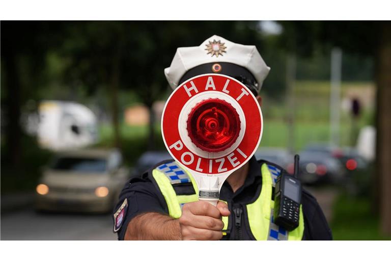 Ein Polizeibeamter hält einen Anhaltestab in einer 30er-Zone während des Blitzermarathons im Stadtteil Wilhelmsburg.