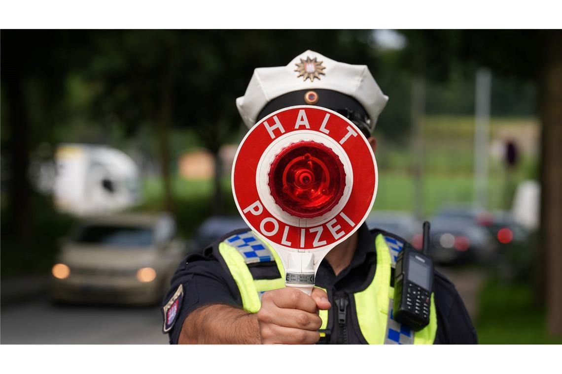 Ein Polizeibeamter hält einen Anhaltestab in einer 30er-Zone während des Blitzermarathons im Stadtteil Wilhelmsburg.