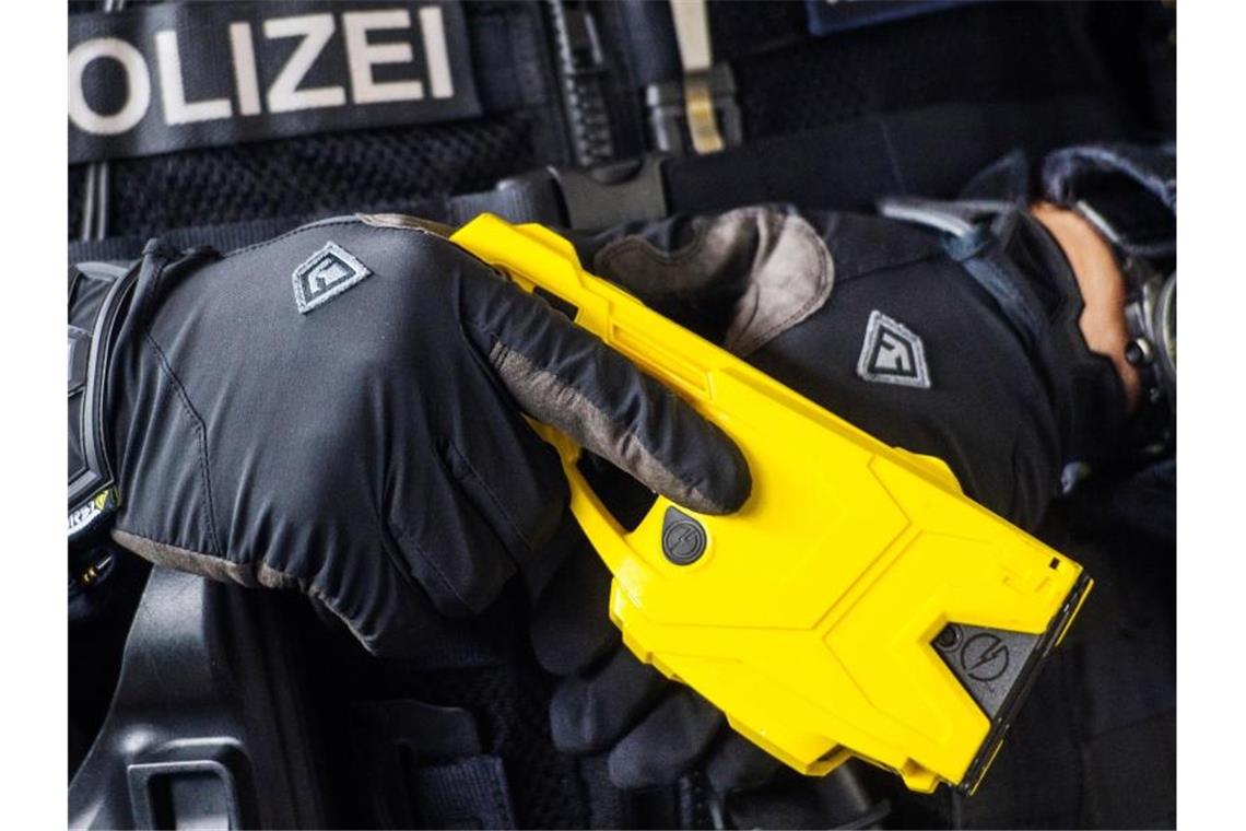 Ein Polizeibeamter hält einen sogenannten Taser. Foto: Andreas Arnold/dpa/Archivbild