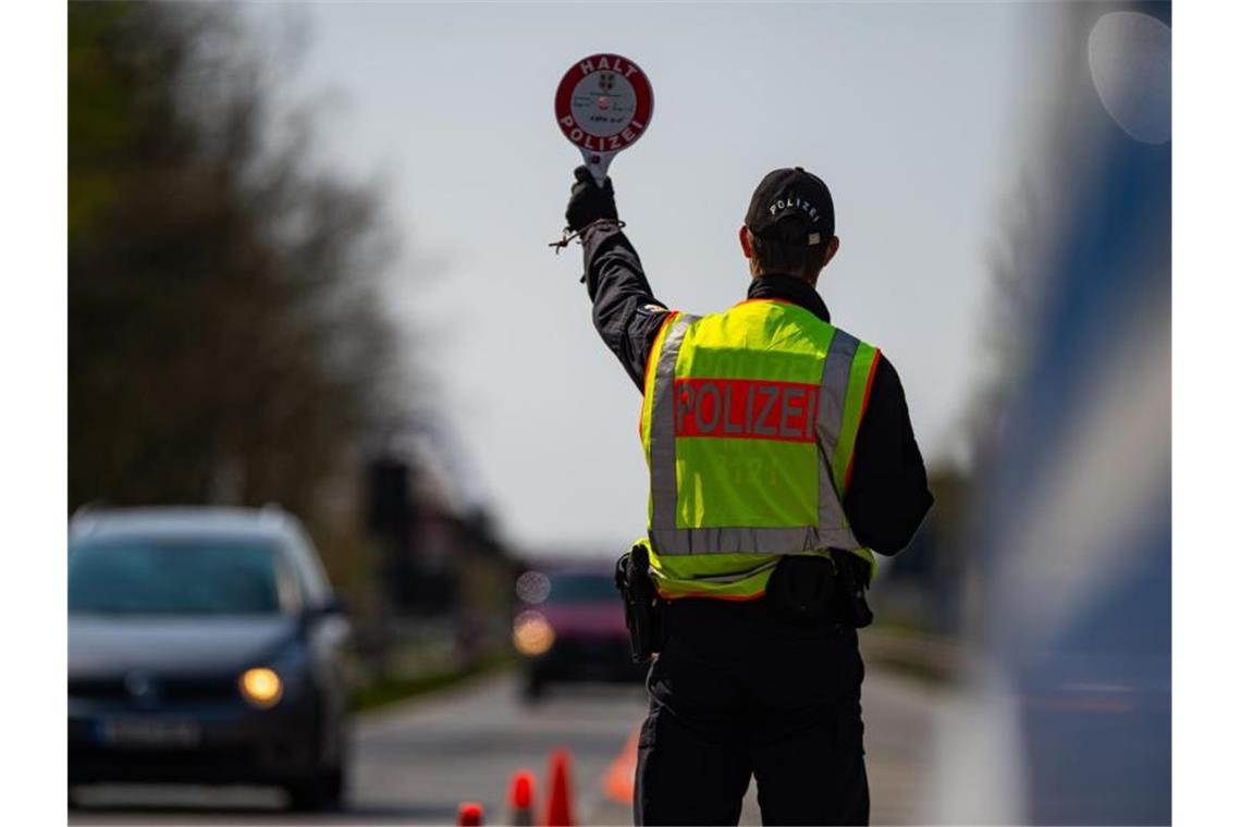 Ein Polizeibeamter kontrolliert hinter der Landesgrenze von Niedersachsen die Zufahrt nach Mecklenburg-Vorpommern. Foto: Philipp Schulze/dpa