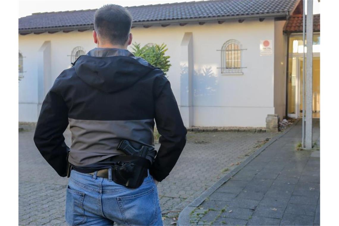 NRW: Staatsschutz durchsucht Wohnungen wegen Terrorverdachts Ein Polizeibeamter sichert einen Einsatzort in Düren. Foto: Ralf Roeger/dpa