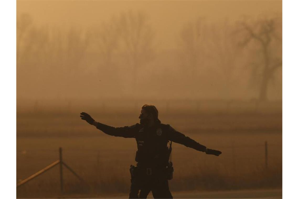 Tausende fliehen in Colorado vor Waldbränden Ein Polizeibeamter sichert im Brandgebiet eine Straße. Foto: Hyoung Chang/The Denver Post/dpa