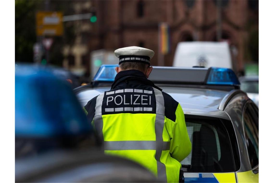Mann sammelt zahlreiche Waffen und bekommt Polizeibesuch Ein Polizeibeamter steht zwischen zwei Einsatzfahrzeugen der Polizei. Foto: Philipp von Ditfurth/dpa/Symbolbild