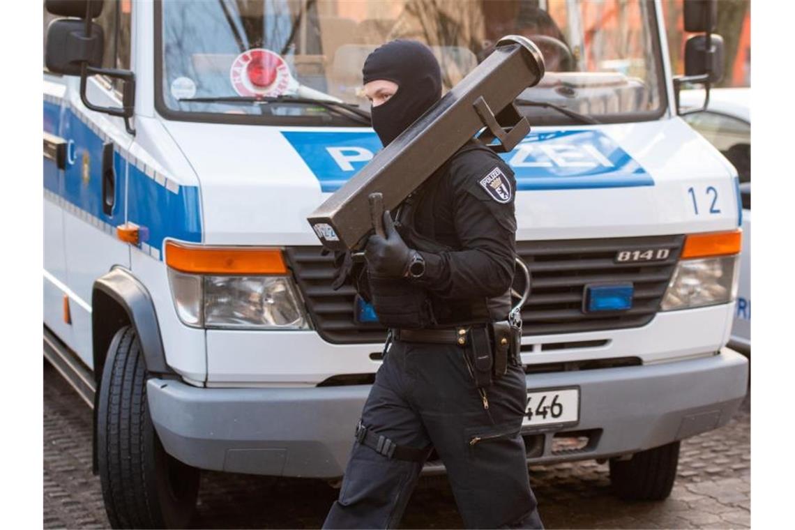 Razzia gegen radikale Islamisten Ein Polizeibeamter trägt nach einer Razzia im Märkischen Viertel in Berlin eine Ramme. Foto: Christophe Gateau/dpa