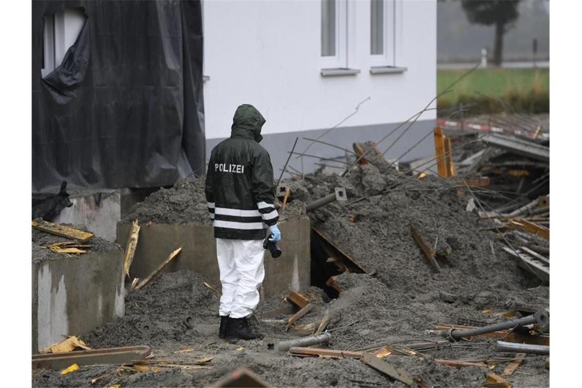 Ein Polizeibeamter untersucht eine Baustelle im bayerischen Denklingen. Vier Arbeiter sind dort beim Einsturz einer Betondecke getötet worden, ein Arbeiter wurde bei dem Unfall leicht verletzt. Foto: Matthias Balk/dpa