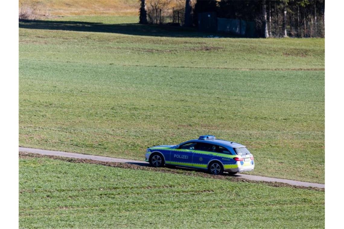 Affe treibt sich weiter im Wald in Südbaden herum Ein Polizeifahrzeug fährt auf der Suche nach Affen über einen Feldweg. Foto: Philipp von Ditfurth/dpa
