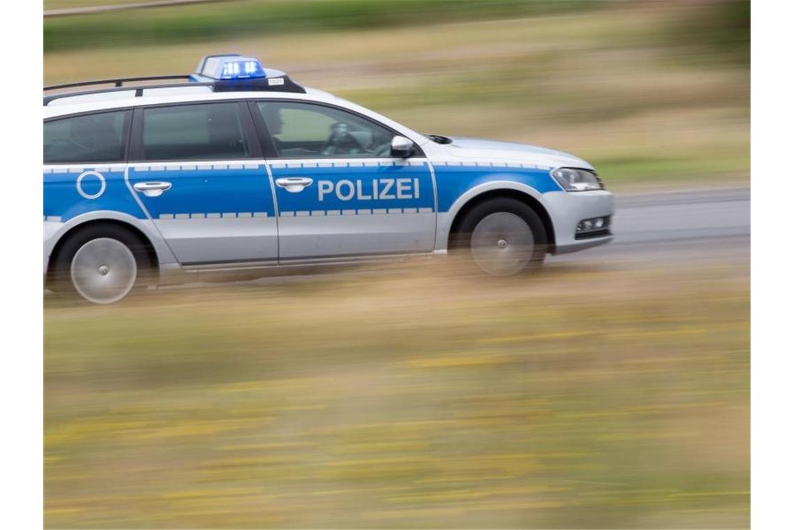 Ein Polizeifahrzeug fährt mit Blaulicht auf der Landstraße. Foto: Friso Gentsch/dpa/Symbolbild
