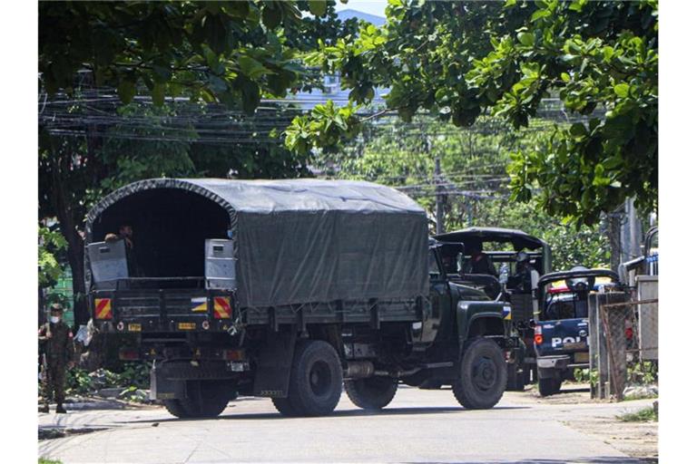Ein Polizeifahrzeug steht auf einer Straße, um eine Versammlung von Anti-Putsch-Demonstranten in Yangon zu verhindern. Foto: --/AP/dpa