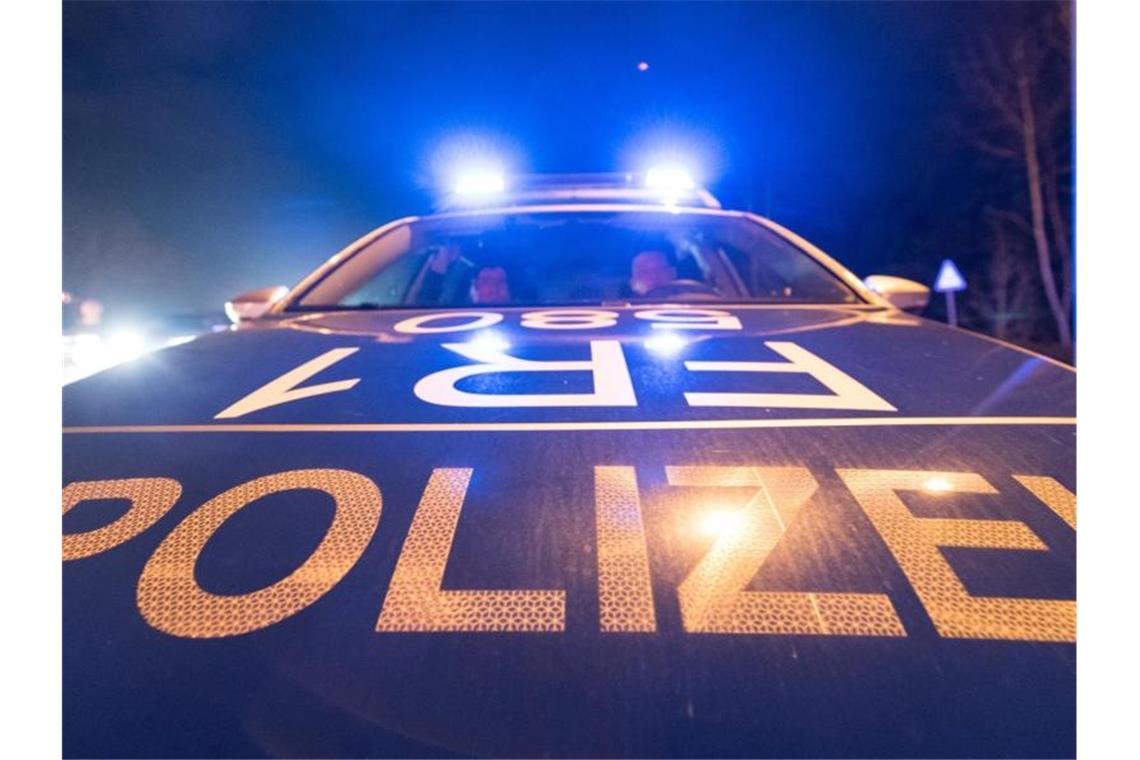 Ein Polizeifahrzeug steht mit angeschaltetem Blaulicht auf der Straße. Foto: Patrick Seeger/dpa/Symbolbild