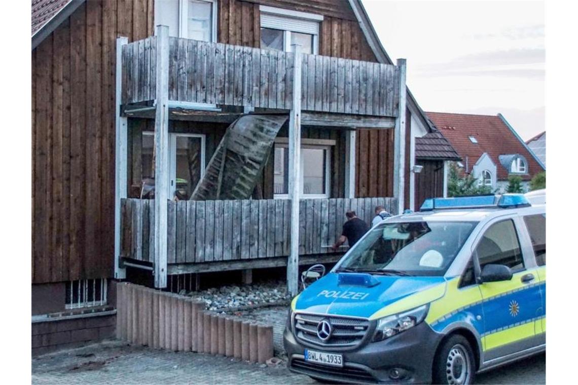 Ein Polizeifahrzeug steht vor einem Haus, an dem ein Balkon eingebrochen ist. Foto: Boehmler/SDMG