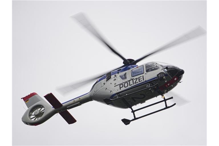 Ein Polizeihubschrauber fliegt bei einem Sucheinsatz über eine Stadt. Foto: Robert Michael/dpa-Zentralbild/ZB/Symbolbild