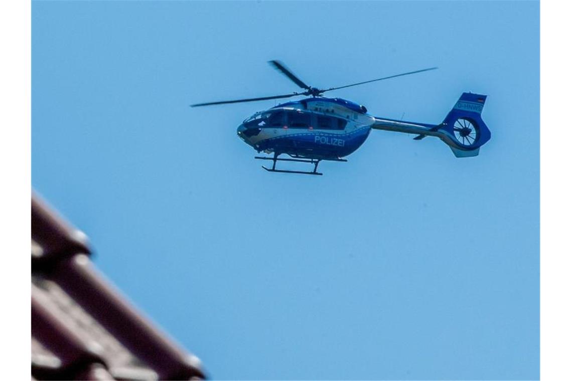 Ein Polizeihubschrauber kreist über Diepenau. Foto: Lino Mirgeler/dpa