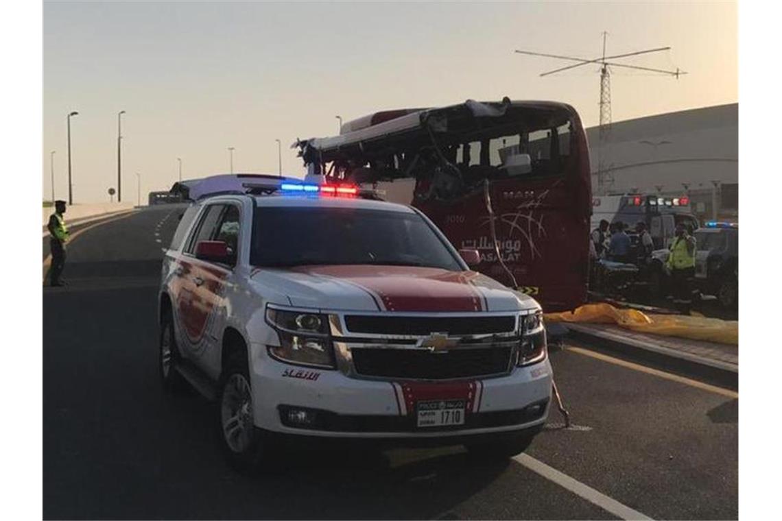 17 Passagiere sterben bei Busunfall in Dubai Ein Polizeiwagen steht an der Unfallstelle neben dem aufgerissenen Bus. Foto: Dubai Police HQ/AP