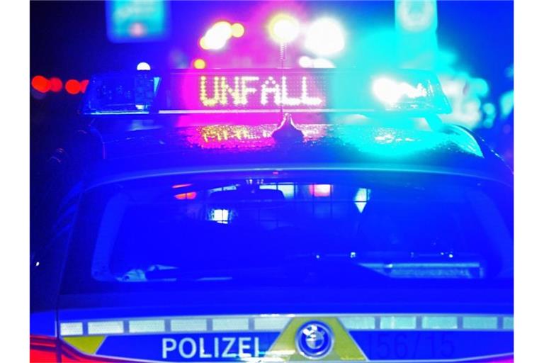 Ein Polizeiwagen steht mit eingeschaltetem Blaulicht an einer Unfallstelle. Foto: Stefan Puchner/dpa/Symbolbild