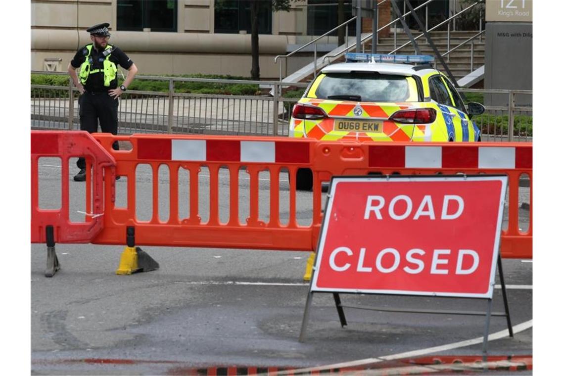 Ein Polizist bewacht eine Straßensperre im Stadtzentrum nach der Messerstecherei in Forbury Gardens. Foto: Jonathan Brady/PA Wire/dpa