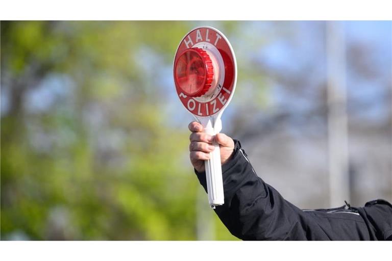 Ein Polizist der winkt Autofahrer zu einer Kontrolle raus. In Sigmaringen hat die Polizei einen VW Golf mit drei Erwachsenen und fünf Kindern an Bord gestoppt (Symbolfoto).
