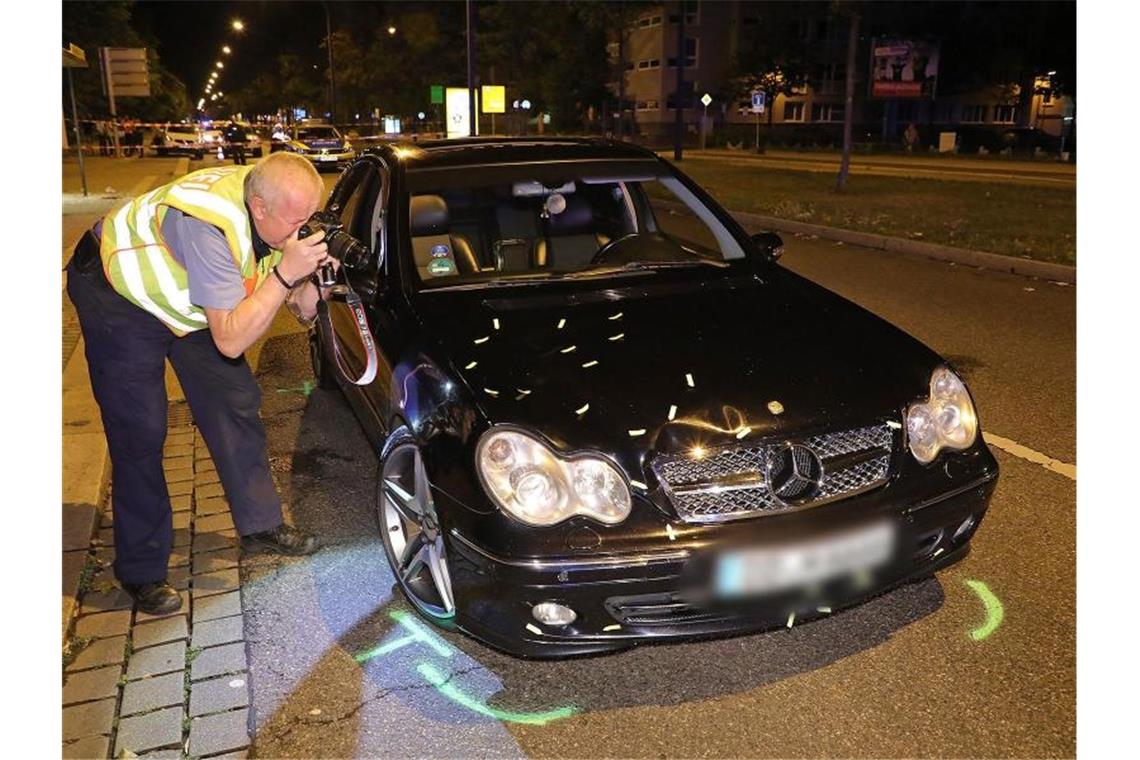 Ein Polizist fotografiert einen schwarzen Mercedes, der in den Verkehrsunfall verwickelt war. Foto: Roland Halkasch/dpa-Zentralbild/dpa