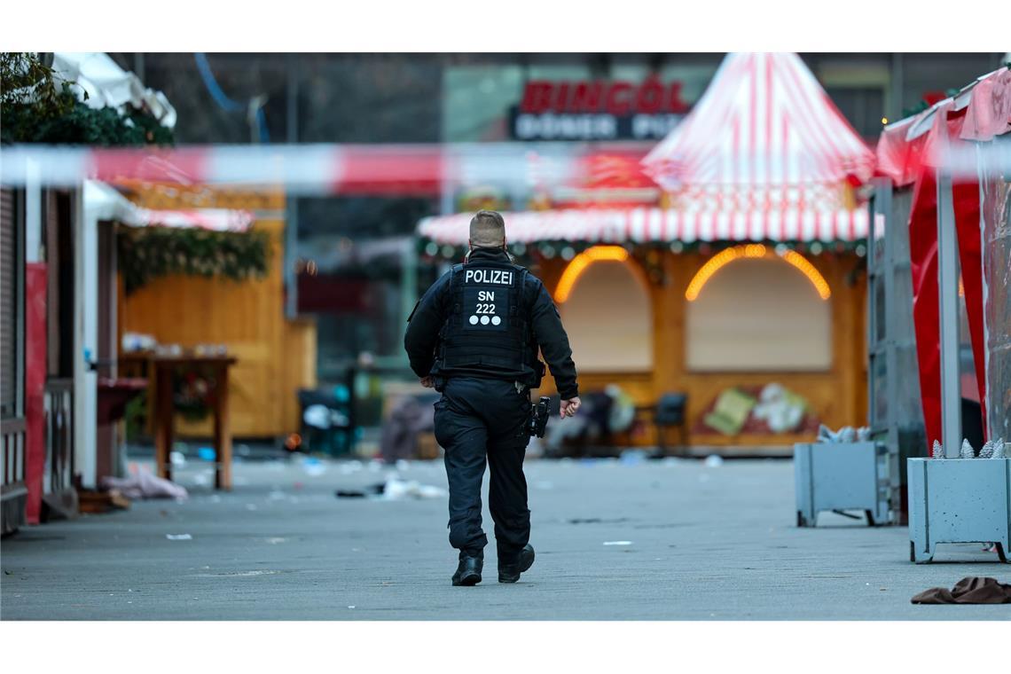 Bilder des Tages Ein Polizist geht hinter einer Absperrung am Magdeburger Weihnachtsmarkt.