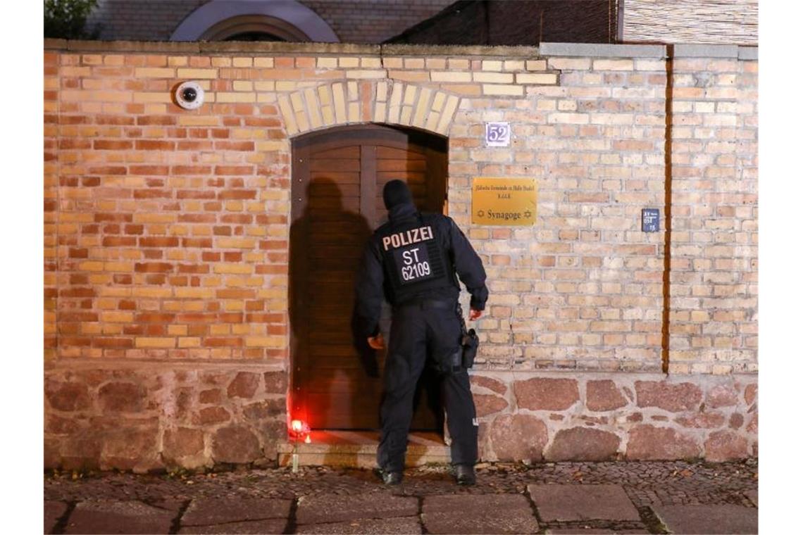 Seehofer garantiert Juden nach Anschlag Sicherheit Ein Polizist geht zum Eingang der Synagoge in Halle. Am Vortag hatte hier ein schwerbewaffneter Täter versucht, in die Synagoge einzudringen und dort unter Dutzenden Gläubigen ein Blutbad anzurichten. Foto: Jan Woitas/dpa-Zentralbild/dpa