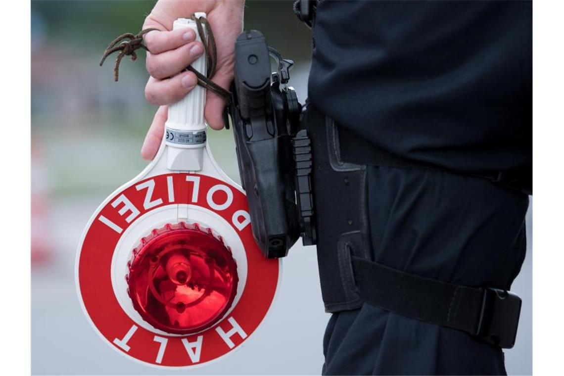 Ein Polizist hält eine Kelle mit der Aufschrift "Halt. Polizei" in der Hand. Foto: Sven Hoppe/dpa/Symbolbild