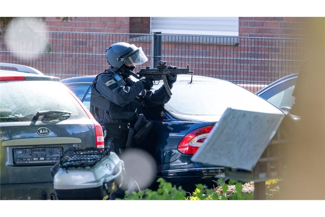 Ein Polizist hält in Moers eine Maschinenpistole im Anschlag. Zuvor war es zu einer Auseinandersetzung am Haus einer religiösen Gemeinde gekommen.