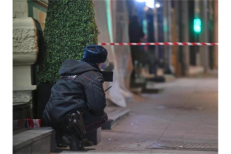 Ein Polizist inspiziert den Tatort an der Zentrale des FSB in Moskau. Foto: Maxim Grigoryev/TASS/dpa