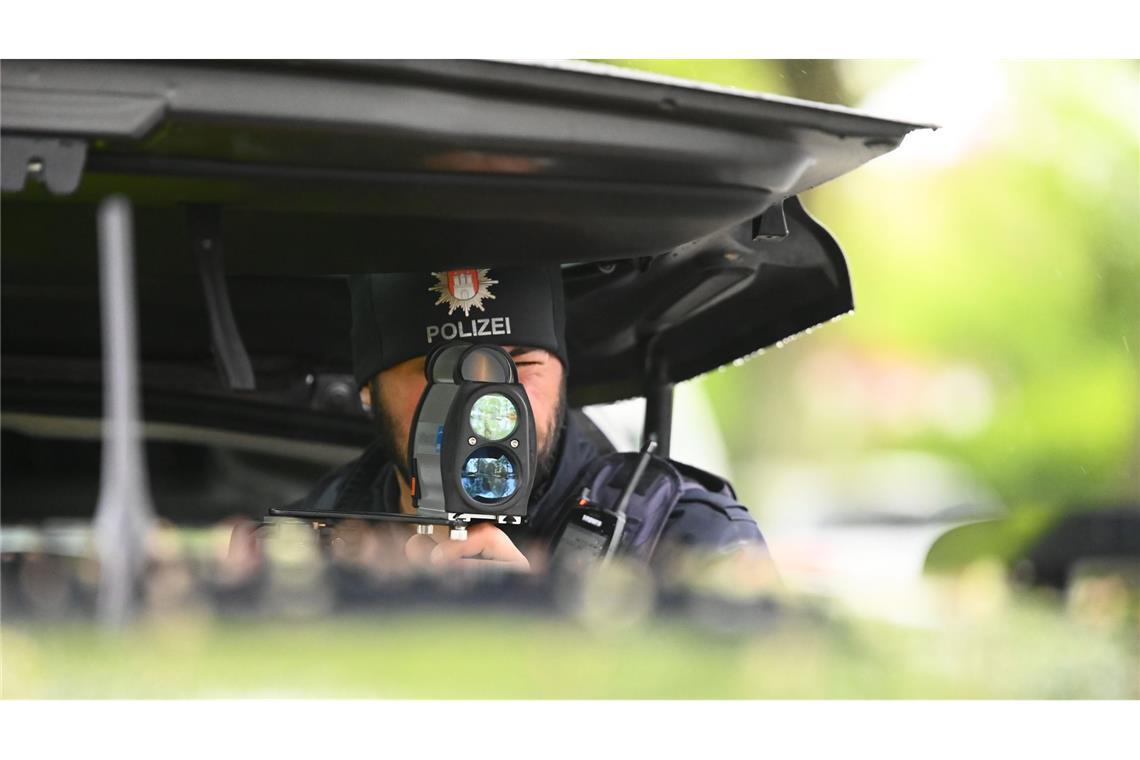 Ein Polizist kontrolliert mit einem Messgerät die Geschwindigkeit von Fahrzeugen in einer 30er-Zone. Die Polizei in Hamburg nimmt seit Montag Geschwindigkeitssünder bei der sogenannten Speedweek ins Visier.