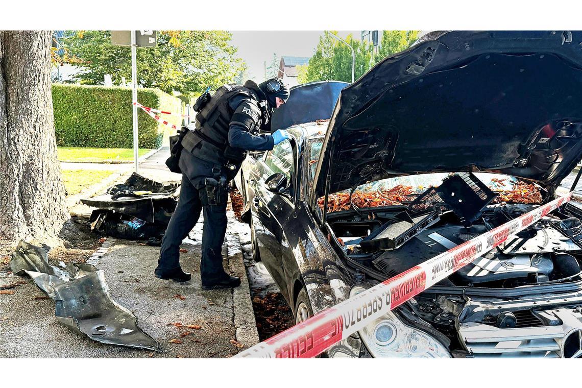 Streit um Vaterschaft bei Tochter führte zu Eskalation mit zwei Toten in München Ein Polizist mit Schutzweste steht an einem PKW, der gebrant hatte. Ein Brand in einem Münchner Einfamilienhaus hat einen Großeinsatz von Polizei und Feuerwehr ausgelöst.