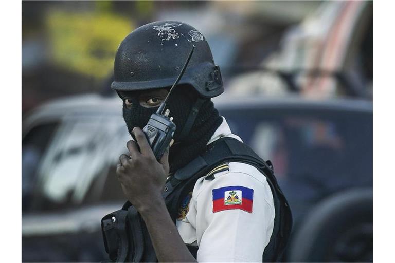 Ein Polizist patrouilliert an einer Kreuzung in Port-au-Prince. Zwei vor über einem Monat in Haiti entführte Ausländer sind freigelassen worden. Foto: Matias Delacroix/AP/dpa