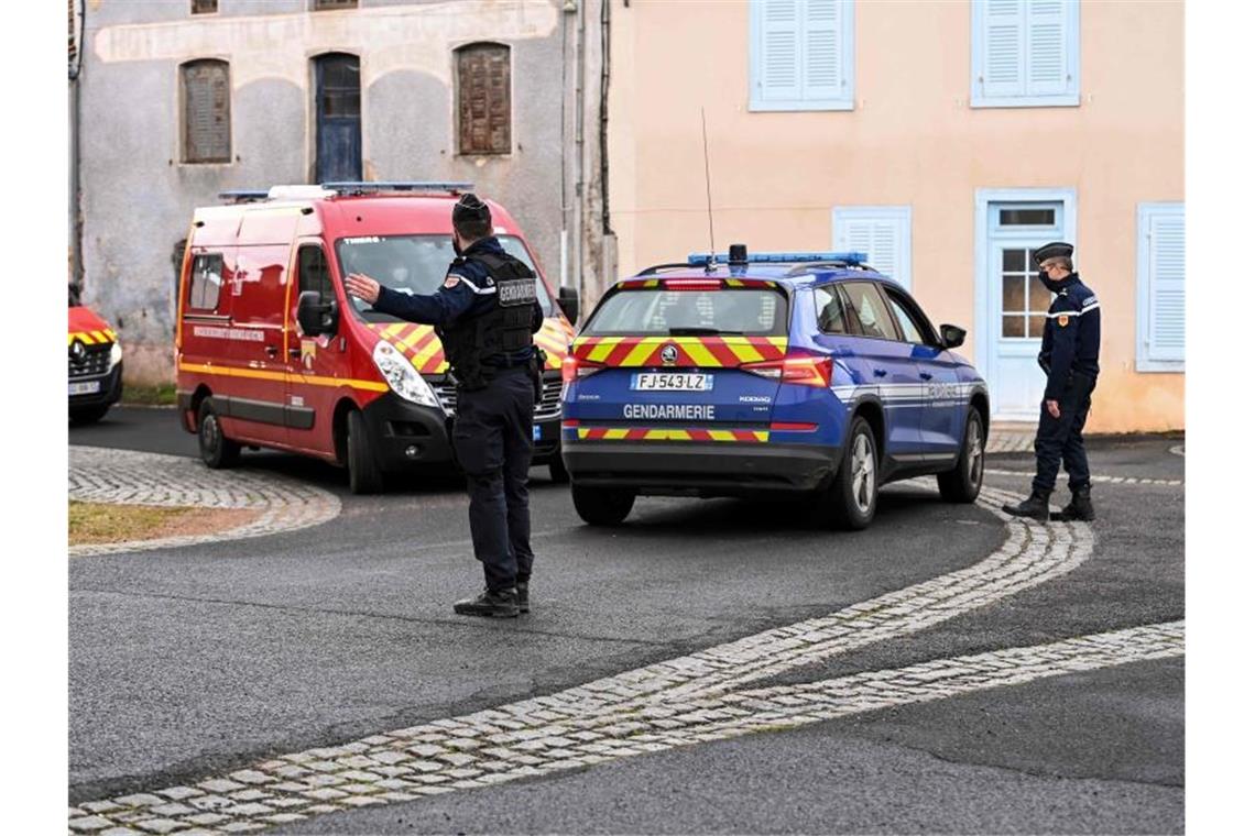 Ein Polizist regelt den Verkehr für vorbeifahrende Einsatzfahrzeuge der Feuerwehr. In einem französischen Dorf hat ein Mann laut Agenturberichten drei Polizisten erschossen. Foto: Olivier Chassignole/AFP/dpa