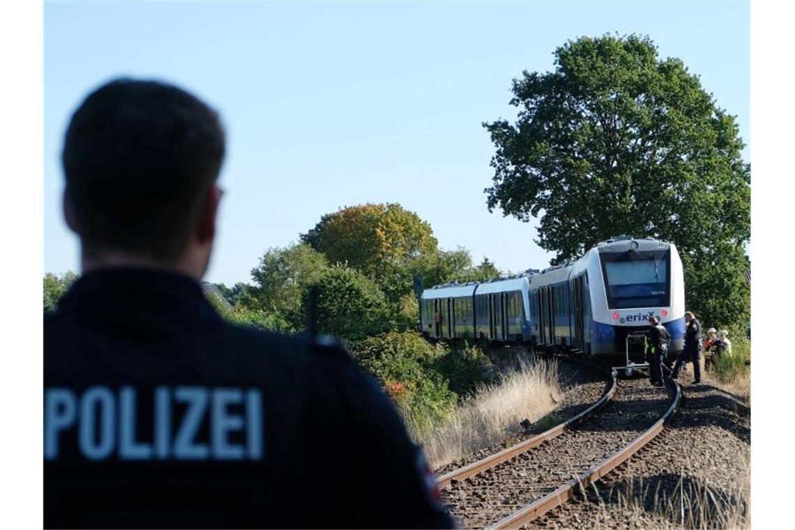 Ein Polizist steht in der Nähe des Unglücksortes auf dem Bahngleis bei Isenbüttel. Foto: Peter Steffen