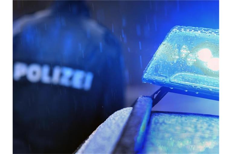 Ein Polizist steht neben einem Einsatzwagen. Foto: Karl-Josef Hildenbrand/Archivbild