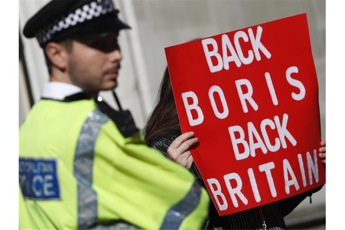 Ein Polizist steht neben einem Pro-Brexit-Demonstranten in London. Premier Boris Johnson will vor allem eine Änderung beim Backstop erreichen. Foto: Alastair Grant/AP