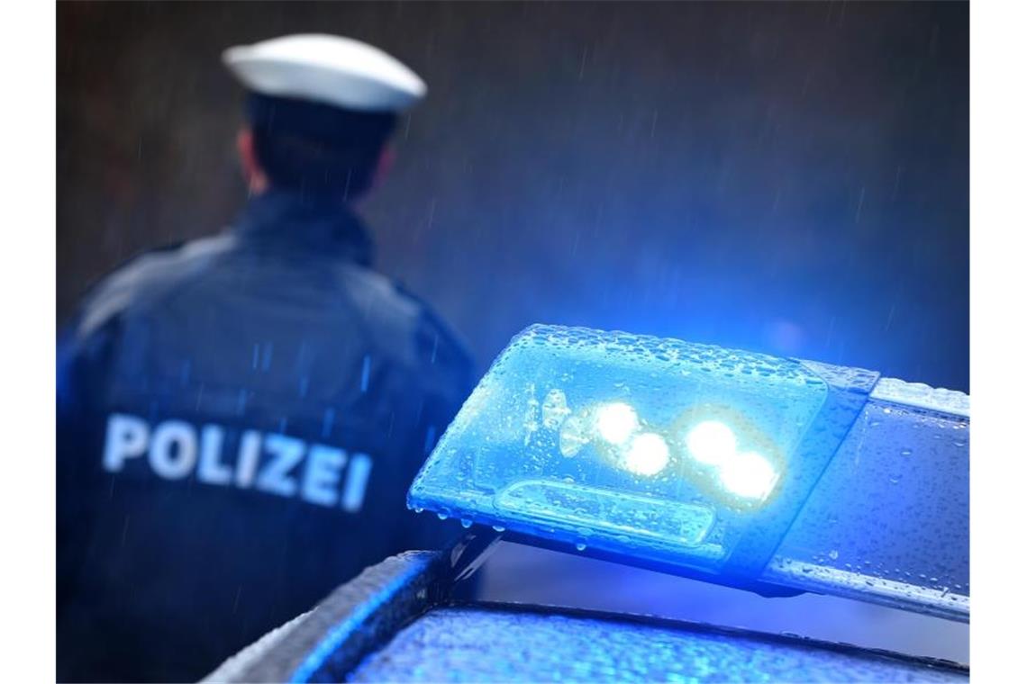 Ein Polizist steht vor einem Streifenwagen. Foto: Karl-Josef Hildenbrand/dpa/Symbolbild
