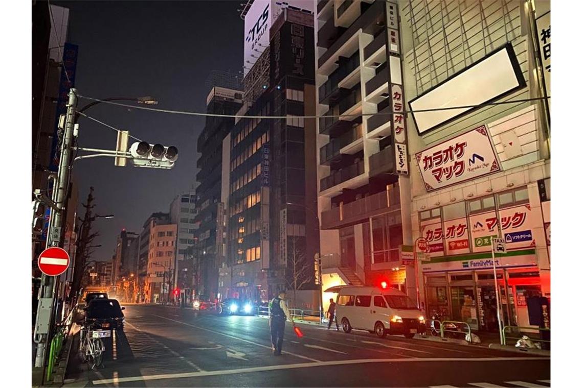 Neues starkes Erdbeben in Fukushima weckt böse Erinnerungen Ein Polizist steht während eines Stromausfalls in Tokio auf der Straße und leitet den Verkehr. Foto: -/Kyodo News/AP/dpa