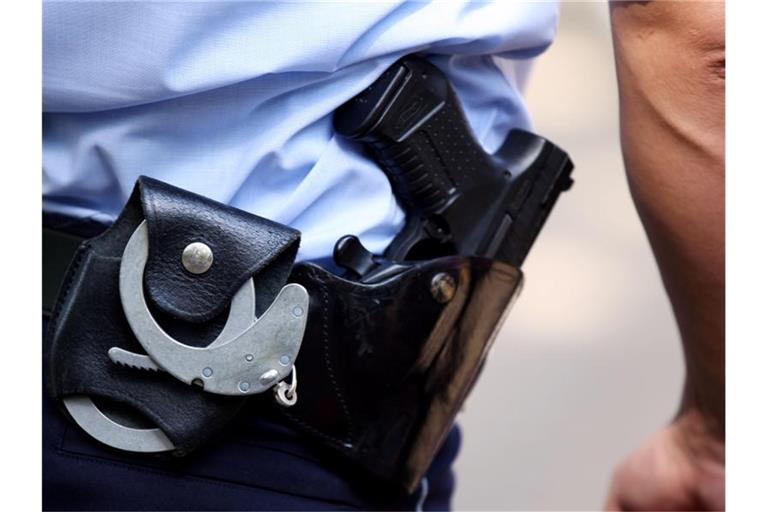 Ein Polizist trägt eine Pistole am Gürtel. Foto: Oliver Berg/dpa/Symbolbild