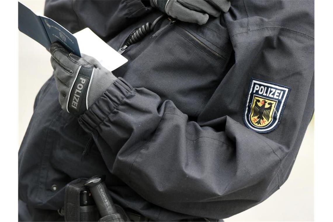 Pistorius für Studie zu rassistischen Polizeikontrollen Ein Polizist überprüft Personalien. Beim Racial Profiling werden Menschen auf Grundlage von Stereotypen und äußerlichen Merkmalen als verdächtig eingestuft und überprüft. Foto: Felix Kästle/dpa