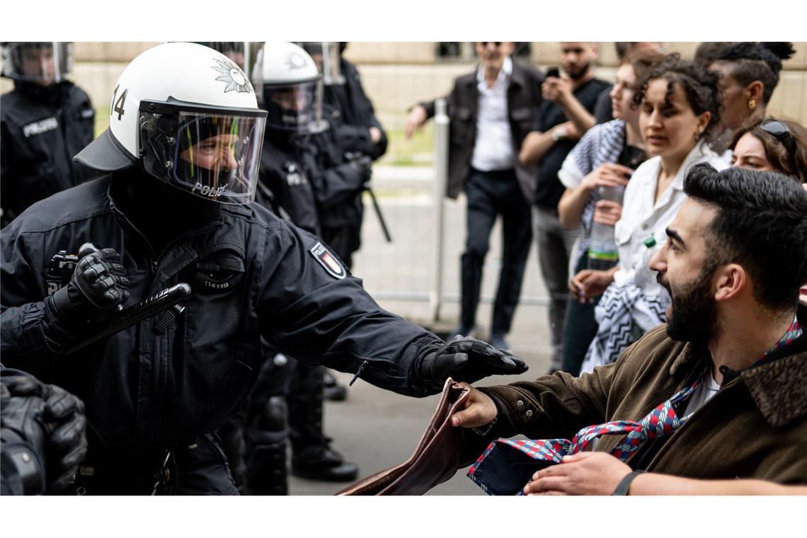 Ein Polizist und ein Demonstrant stoßen bei der Demonstration in Berlin-Mitte aufeinander. Die Polizei war mit rund 900 Kräften in der Stadt im Einsatz.