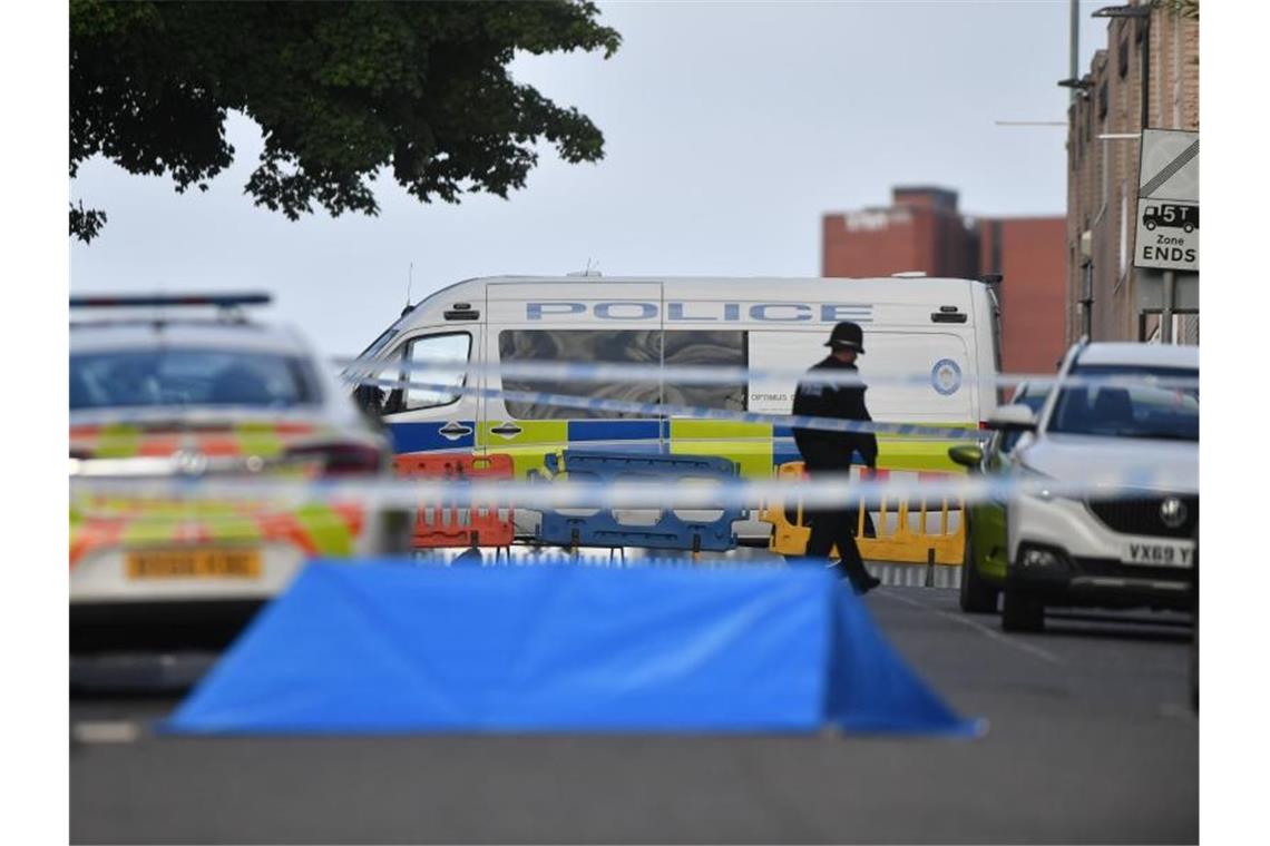 Ein Polizist und Fahrzeuge der Polizei stehen an einer Absperrung in der Irving Street in Birmingham. Foto: Jacob King/PA Wire/dpa