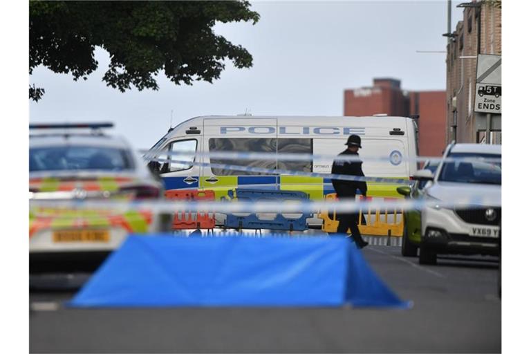 Ein Polizist und Fahrzeuge der Polizei stehen an einer Absperrung in der Irving Street in Birmingham. Foto: Jacob King/PA Wire/dpa