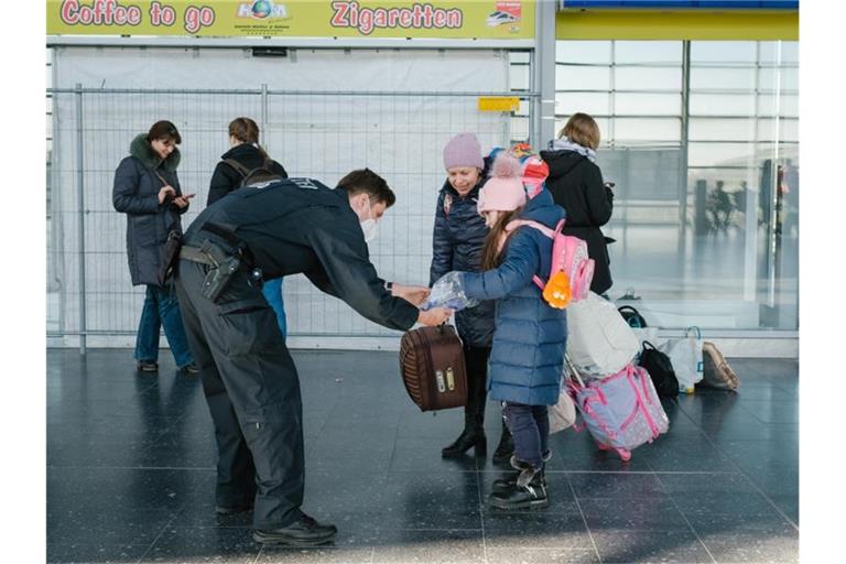 Ein Polizist verteilt im niedersächsischen Laatzen Schokolade an ein aus der Ukraine geflüchtetes Mädchen. Foto: Ole Spata/dpa