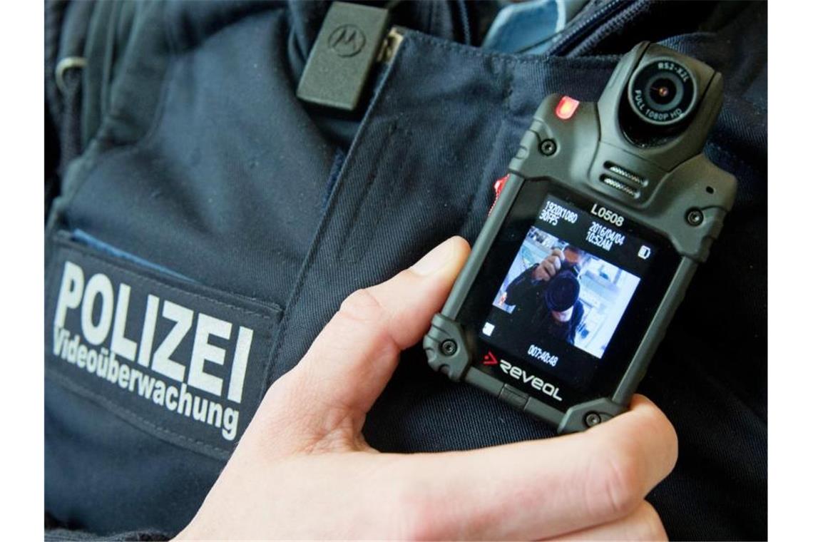 Ein Polizist zeigt eine Bodycam zur Videoüberwachung. Foto: Kay Nietfeld/Archivbild