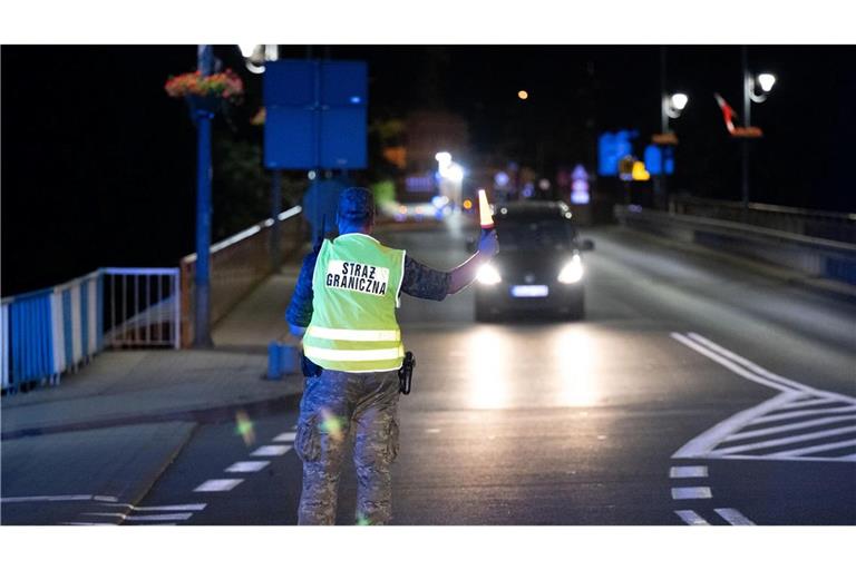 Ein polnischer Grenzschützer steht hinter der Stadtbrücke von Görlitz und winkt ein Fahrzeug zur Kontrolle raus. Polen hat vorübergehend die Grenzkontrollen an der deutsch-polnischen Grenze wieder aufgenommen. (Foto aktuell)