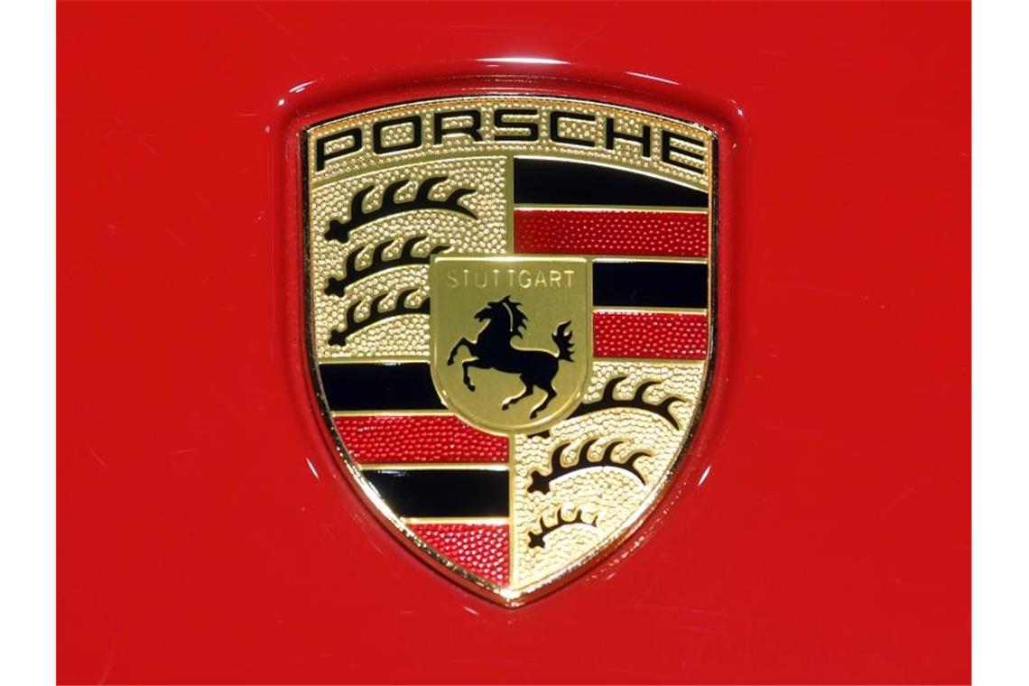 Fortsetzung von Untreue-Ermittlungen gegen Porsche Ein Porsche Logo ist auf rotem Hintergrund zu sehen. Foto: Uli Deck/dpa/Archivbild