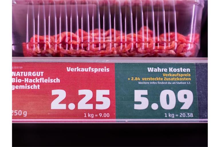 Ein Preisschild in einem Supermarkt weist neben dem Verkaufspreis auch den „wahren Preis“ aus. Foto: Rolf Vennenbernd/dpa