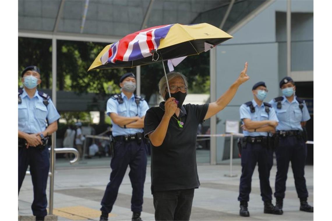 Hongkonger Aktivisten zu Haftstrafen verurteilt Ein pro-demokratischer Aktivist protestiert vor einem Gericht in Hongkong. Foto: Kin Cheung/AP/dpa