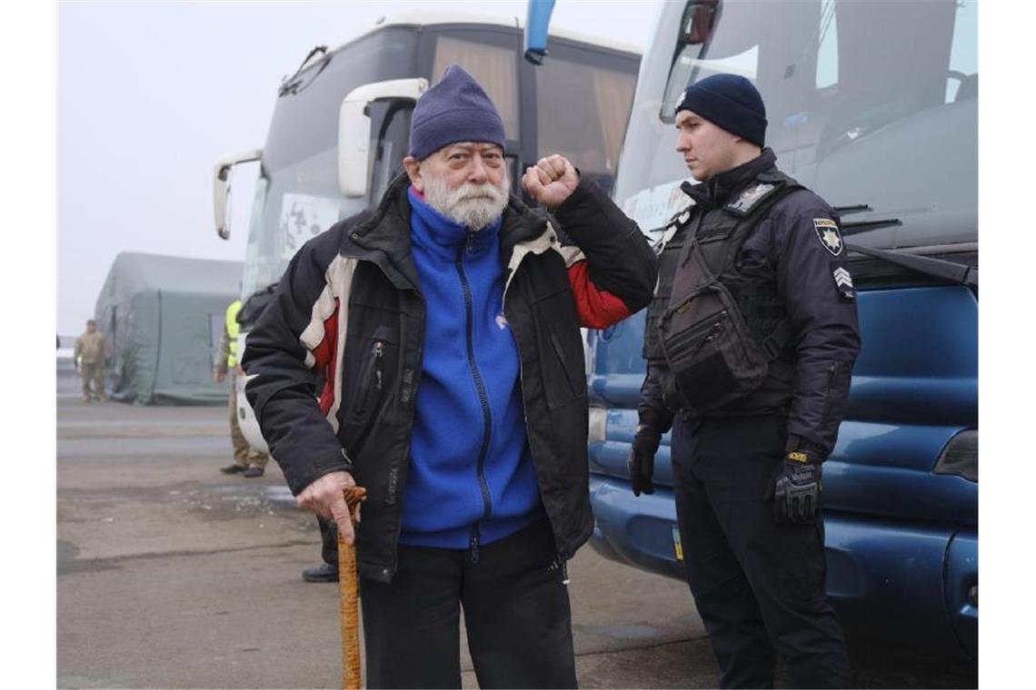 Ein pro-russischer Gefangener wird vor dem Austausch von einem ukrainischen Polizisten beaufsichtigt. Foto: Yevgen Honcharenko/Pool EPA/AP/dpa