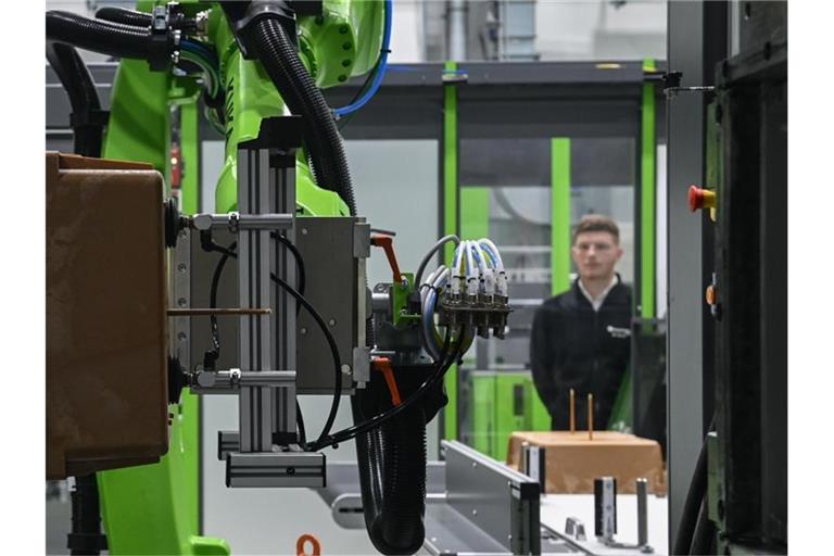 Ein Probebauteil wird von einem Roboter aus einer Spritzgussanlage entnommen. Im Coronajahr 2020 sind die Ausgaben der deutschen Wirtschaft für Forschung und Entwicklung (FuE) erstmals seit sieben Jahren zurückgegangen. Foto: Hendrik Schmidt/dpa-Zentralbild/dpa